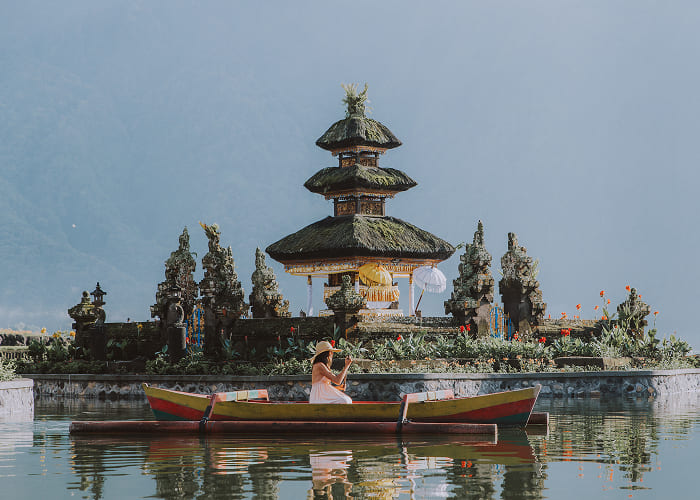 young-woman-traveler-paddling-on-a-wooden-boat-at-2023-11-27-05-19-33-utc 1