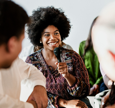 cheerful-woman-speaking-on-a-microphone-in-a-works-2025-02-09-23-56-31-utc 1